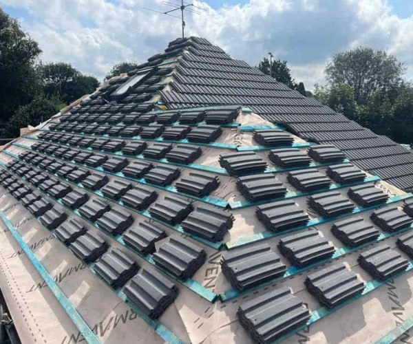 This is a photo of a new hip roof being installed. New felt, battens, and grey tiles have been installed, also a new velux window. Works carried out by GKL Roofing Tickhill