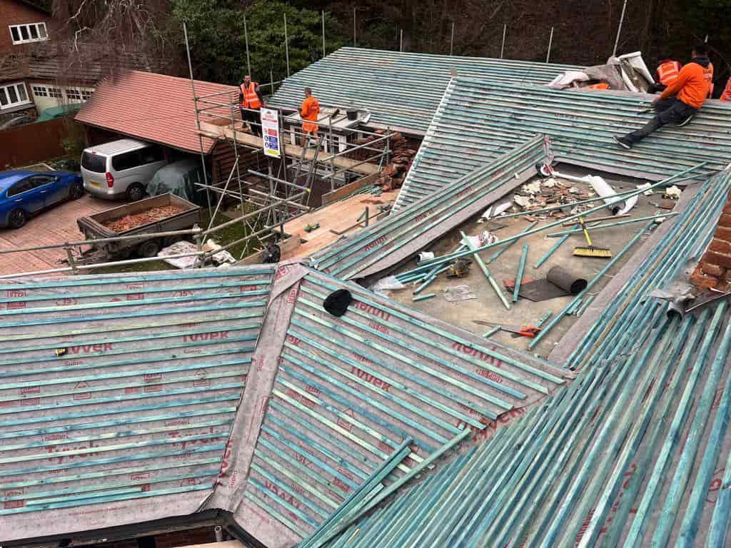 This is a photo of a large re-roof being carried out by GKL Roofing Tickhill, there are multiple sections of pitched roofs adjoining to a central flat roof